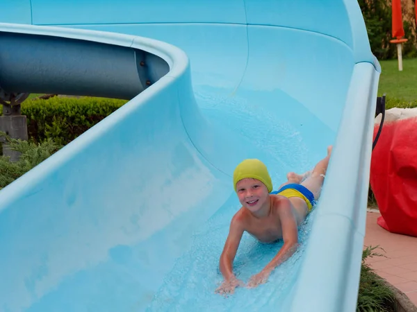 Boy rides water slide rides at the water park — Stock Photo, Image