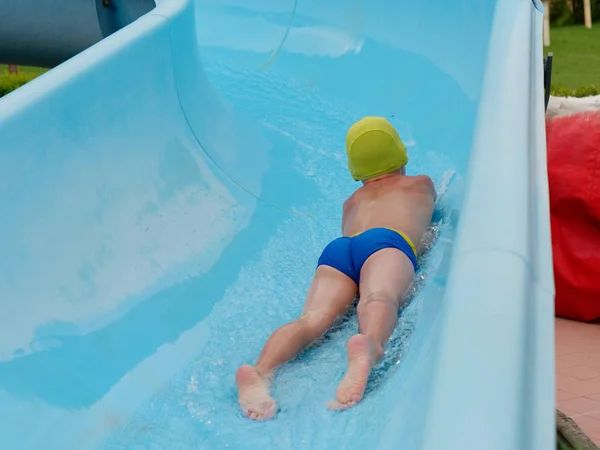 Garçon promenades toboggan aquatique au parc aquatique — Photo