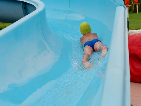 Boy rides water slide rides at the water park — Stock Photo, Image