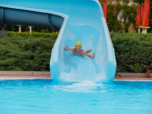 Jongen rijdt waterglijbaan ritten in het waterpark — Stockfoto