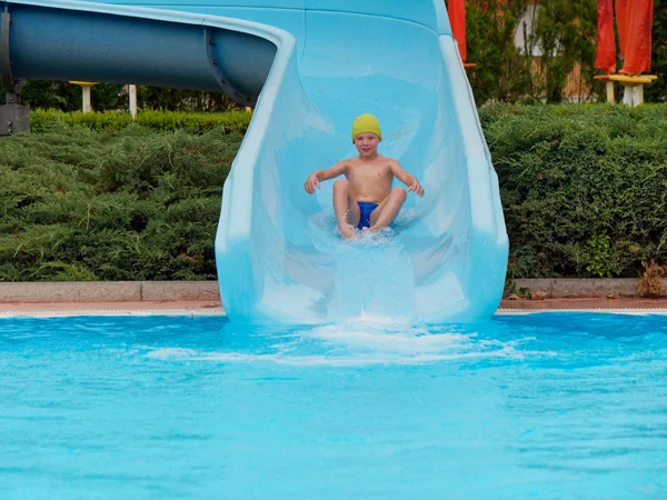 Garçon promenades toboggan aquatique au parc aquatique — Photo