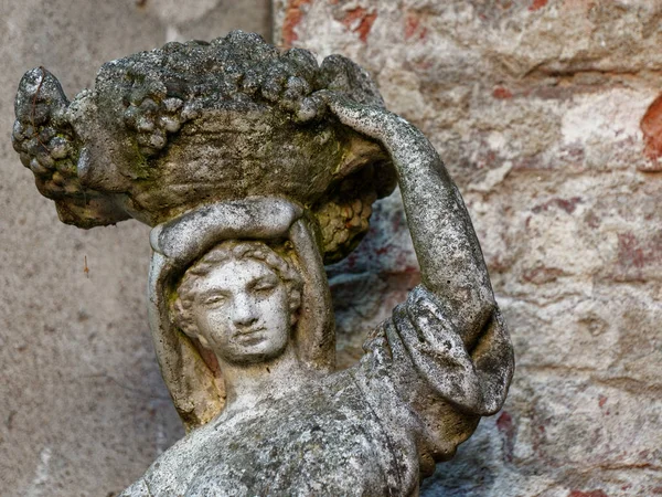 Старая скульптура девушки с кувшином на плече — стоковое фото
