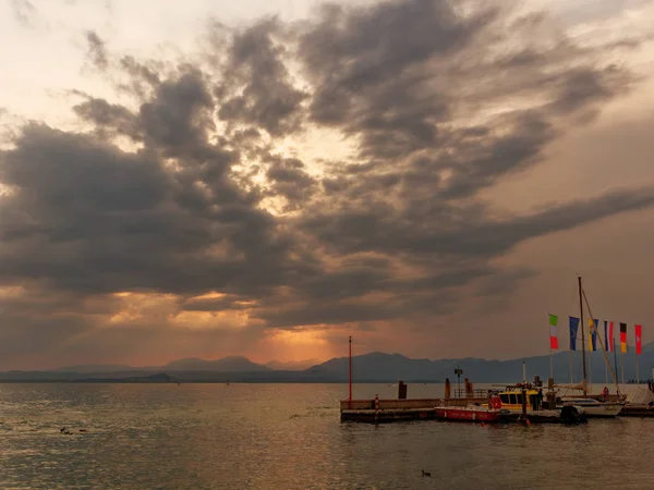 BORDOLINO, ITÁLIA - 6 de agosto de 2019: Belo pôr do sol sobre o Lago de Garda. Barco de turismo — Fotografia de Stock