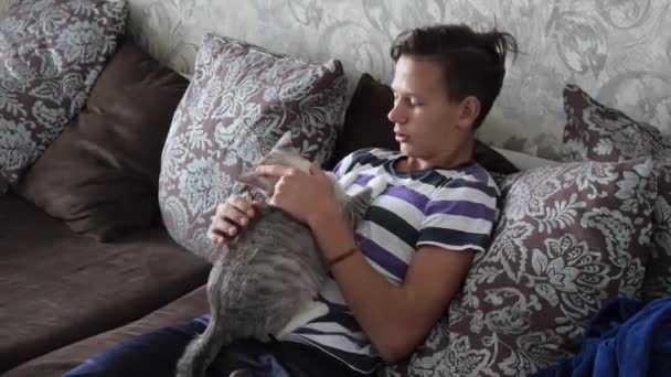 Tinédzser játszik egy gyönyörű szőke macska — Stock videók