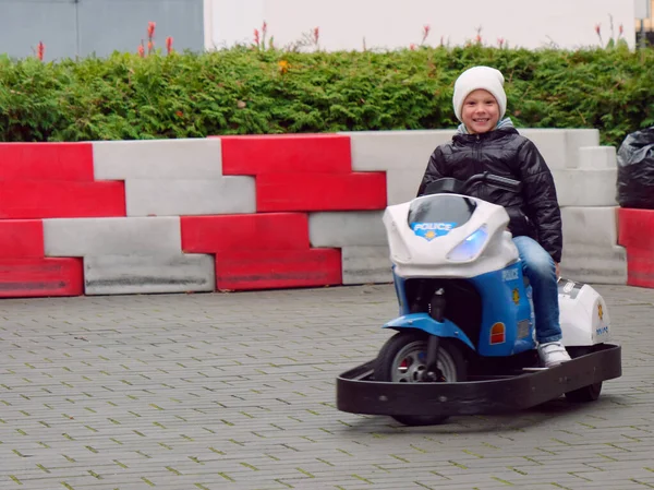 Cheerful boy ride an electric motorcycle for children — Stock Photo, Image