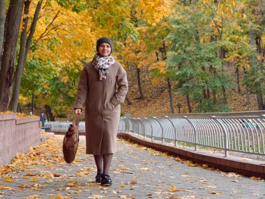 Sonbahar sarı parkında güzel esmer kadın.