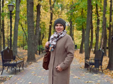 Sonbahar sarı parkında güzel esmer kadın.