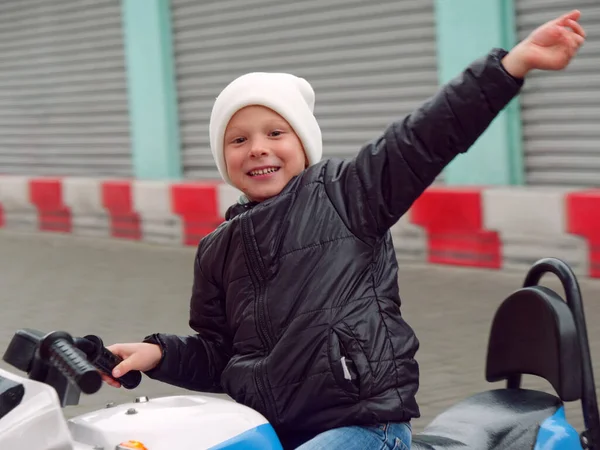 Fröhlicher Junge fährt Elektro-Motorrad für Kinder — Stockfoto