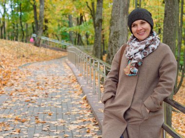 Sonbahar sarı parkında güzel esmer kadın.