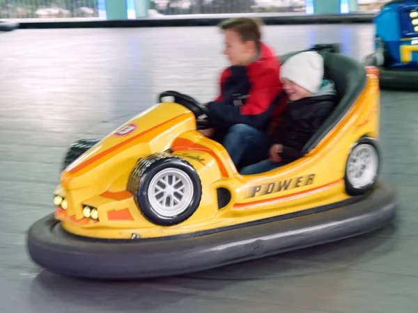 Kinderen rijden een kindervermaak rit elektrische auto 's — Stockfoto