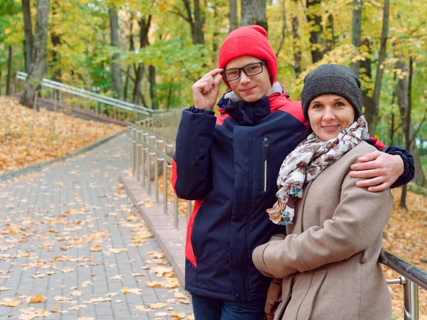 Anne genç oğluyla birlikte sonbahar sarı parkında — Stok fotoğraf