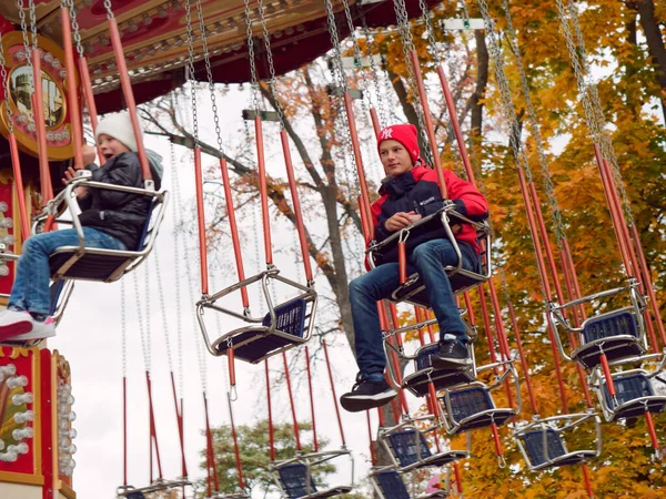 Children ride on the merry-go-round in the fall — Stock Photo, Image