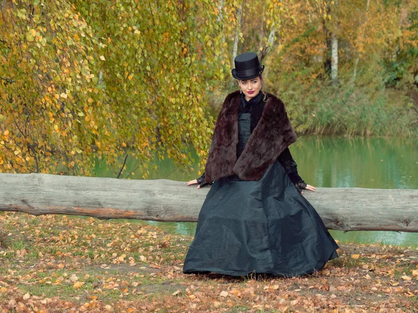 Chica en un vestido negro en las ramas de abedul en otoño — Foto de Stock