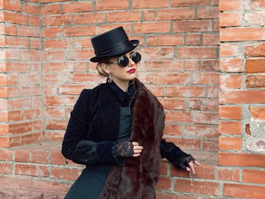 Sonbaharda duvarın arkasında siyah elbiseli bir kız.