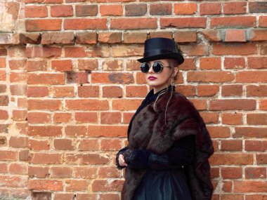 Sonbaharda duvarın arkasında siyah elbiseli bir kız.