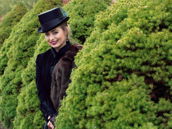 girl in a black dress and hat in autumn