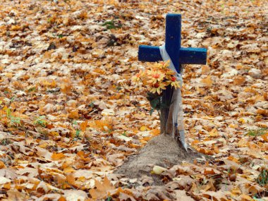 Sonbaharda mezarlıkta eski ahşap haç.