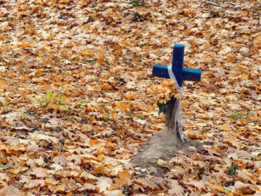 Sonbaharda mezarlıkta eski ahşap haç.