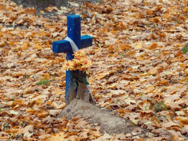 Sonbaharda mezarlıkta eski ahşap haç.