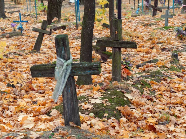 Vieja cruz de madera sobre una tumba en un cementerio en otoño — Foto de Stock