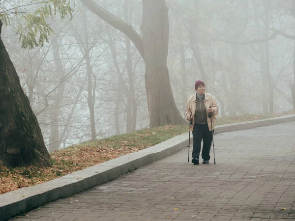 Homel, Białoruś - 23 października 2019: kobieta z pałeczkami skandynawskimi w parku — Zdjęcie stockowe