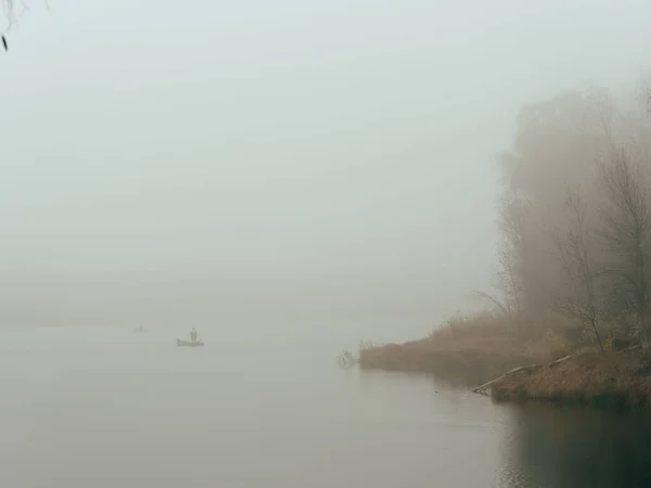 Pêcheurs matin brumeux sur un bateau sur l'eau — Photo