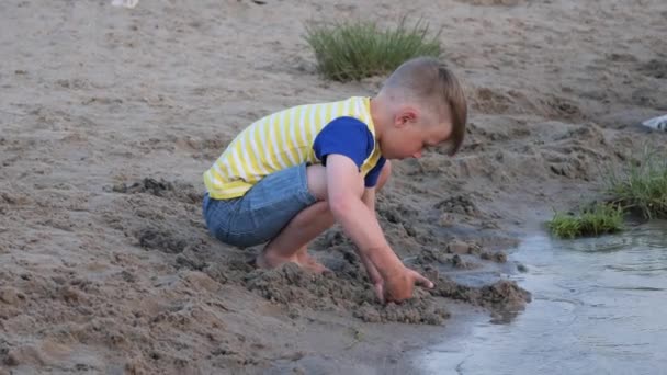 Niño Juega Con Arena Playa Cerca Del Agua — Vídeos de Stock