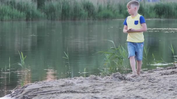 Jongen Speelt Met Zand Het Strand Bij Het Water — Stockvideo