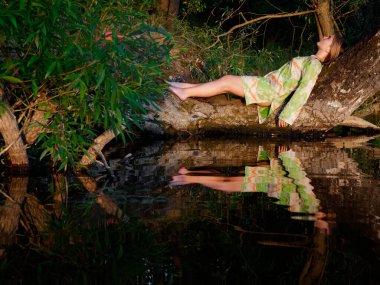 2020 gün batımında suyun üzerindeki ağaçta güzel bir kız.