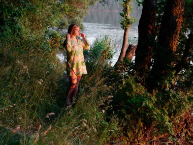 2020 gün batımında yeşil bir çalılıkta güzel bir kız.