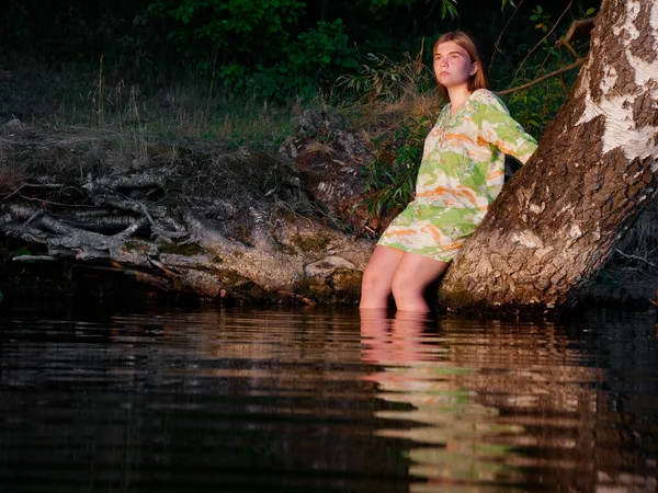 2020年の日没に水の上の木の上の美しい女の子 — ストック写真