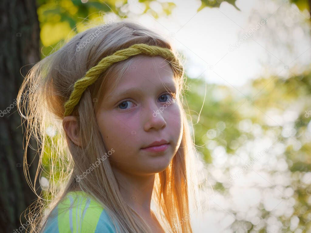 portrait of a blonde girl with blue eyes at sunset in the backlight 2020
