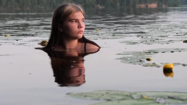 Sjöjungfru flicka i vattnet bland näckrosor vid solnedgången — Stockvideo