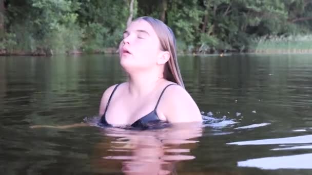 Fille est reflétée dans l'eau sombre au coucher du soleil — Video