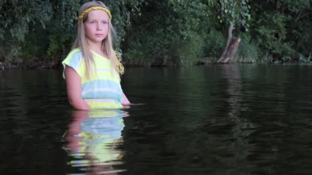 Ragazze bionde con gli occhi azzurri si bagna di vestiti nell'acqua scura di un lago al tramonto — Video Stock