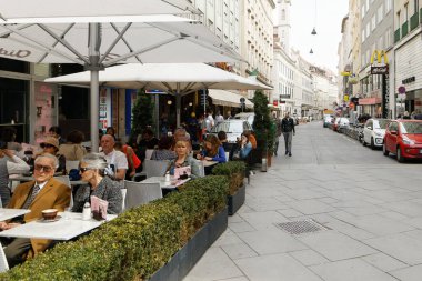 Viyana, Avusturya - 15 Nisan 2018: İnsanlar bir sokak kafesinde masalara oturuyor