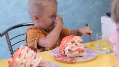 Küçük çocuk büyük bir dilim pasta yiyor.