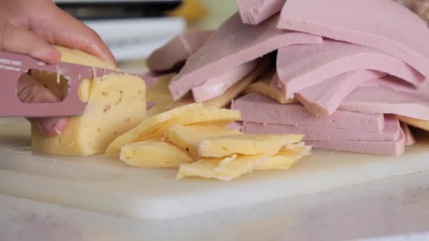 ティーネージャーはチーズとソーセージをナイフで切り — ストック動画