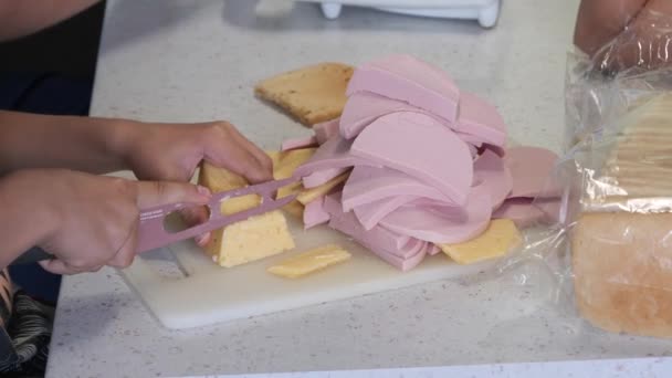 ティーネージャーはチーズとソーセージをナイフで切り — ストック動画