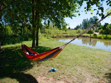 2020 ağaçlarının gölgesinde bir hamakta sallanan çocuk.