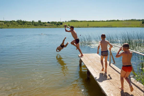 어린이들이 2020 스프링보드에서 호수로 뛰어드는 — 스톡 사진
