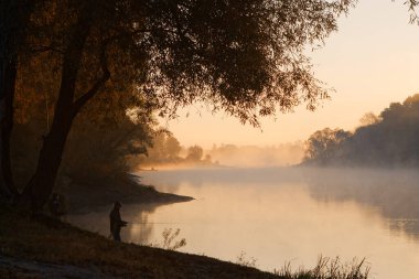 Erkekler yaz sabahı oltayla nehirde balık tutuyor. Güzel sis. 2020