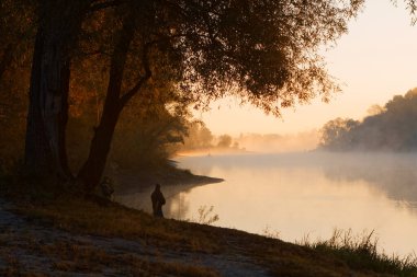 Erkekler yaz sabahı oltayla nehirde balık tutuyor. Güzel sis. 2020