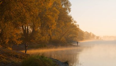 Erkekler yaz sabahı oltayla nehirde balık tutuyor. Güzel sis. 2020