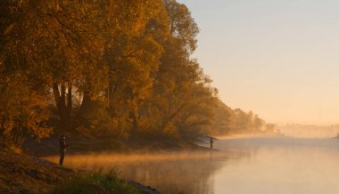 Erkekler yaz sabahı oltayla nehirde balık tutuyor. Güzel sis. 2020