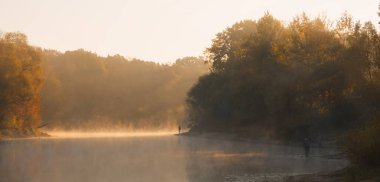 Erkekler yaz sabahı oltayla nehirde balık tutuyor. Güzel sis. 2020