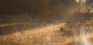 2020 'de gizemli bir gölde teknede balık tutan bir adam.