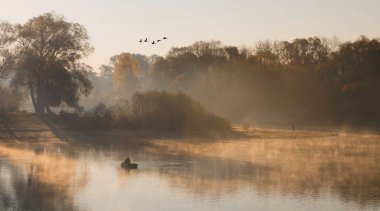2020 'de gizemli bir gölde teknede balık tutan bir adam.
