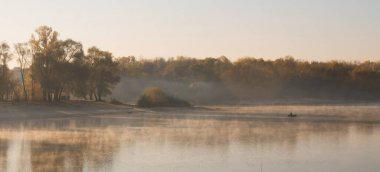 2020 'de gizemli bir gölde teknede balık tutan bir adam.