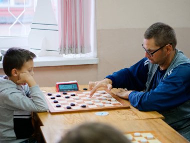 Gomel, BELARUS - 27 Eylül 2020: 2020 Taslak Kulübü 'nde çocuklar ve yetişkinler dama oynuyor